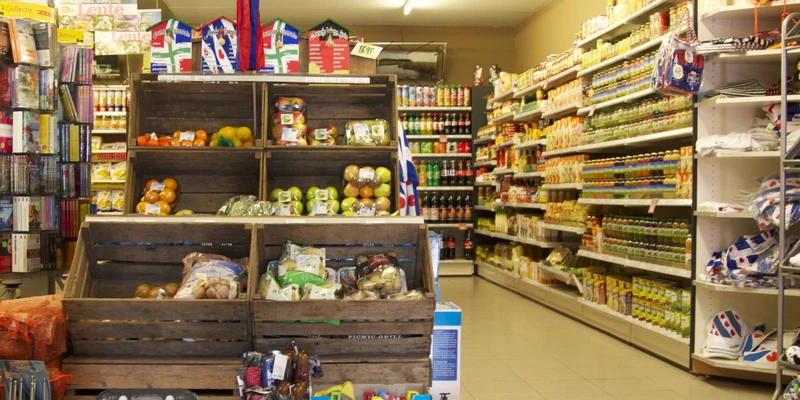 Shelves stocked with groceries and toys stand in a well-lit convenience store at Lauwersoog