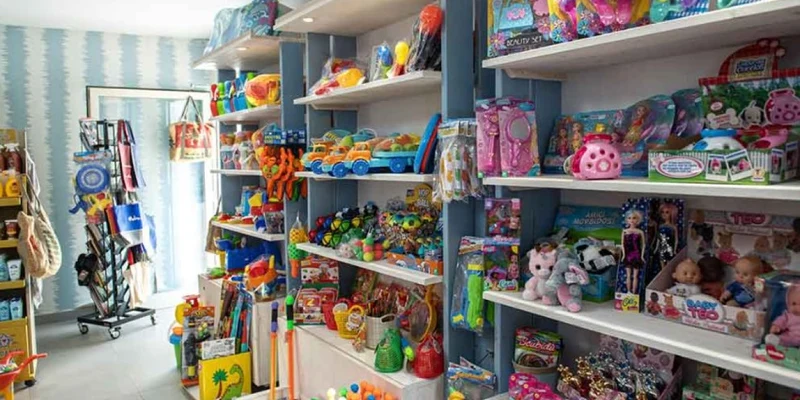 Shelves filled with colorful toys and games are displayed in a brightly lit, organized store at Molino a Fuoco
