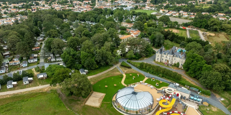 Dome-covered pool and colorful slides in a wooded campsite near residential area at Marvilla Parks Château la Forêt