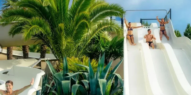 People sliding down water slides near lush tropical plants at Marvilla Parks Pommeraie de l'Océan