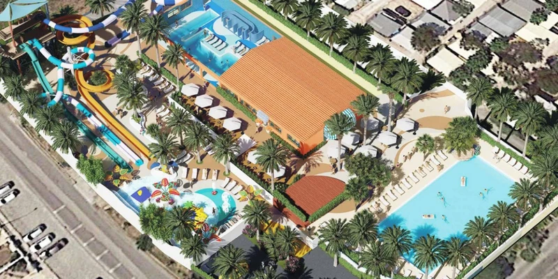 Water park featuring slides and pools surrounded by lounge chairs and palm trees at Yelloh! Colina do Sol